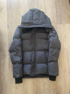 Grå Canada Goose Macmillian  - Säljer min gråa Canada Goose Macmillian. Inga skador eller defekter på på den för mer frågor skriv privat.