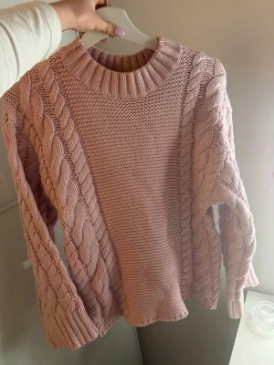 Ljusrosa kabelstickad tröja - Supersöt ljusrosa stickad tröja från Gina Tricot med grova kabelstickade detaljer längs ärmar och sidor. Strl xs, passar S oxå, fint skick 🥰