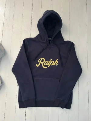 Ralph Lauren hoodie herr, storlek S - Hej! Säljer denna riktigt schyssta hoodie från Ralph Lauren. Den är i storlek M men sitter en storlek litet och passar därför som en S. Den är endast använd någon enstaka gång och är därmed i ett nyskick. Original lappar och påse finns kvar och medföljer naturligtvis vid köp. Jag fraktar alltid snabbt!  Mvh