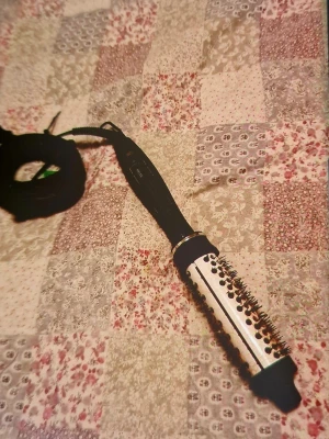 Björn Axén Tools varmluftsborste - Säljer en svart och silverfärgad varmluftsborste från Björn Axén Tools. Borsten har rund form med piggar och ett långt sladdfäste, perfekt för styling av håret. Handtaget är ergonomiskt och har märkets logga tryckt på sidan.