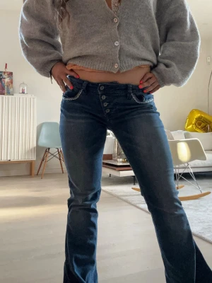 Snygga lågmidjade jeans - Lågmidjade vintage jeans omsydda till bootcut där nere! Glitter på fickorna bak och detaljer på fickorna fram! (Se bild 6 för mer info)