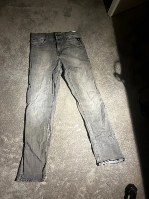 Replay jeans - Säljer ett par grå replay jeans med klassisk femficksdesign och raka ben. Jeansen har en snygg tvättad look och är tillverkade i slitstark bomull. Perfekta för dig som gillar en tidlös och avslappnad stil.  