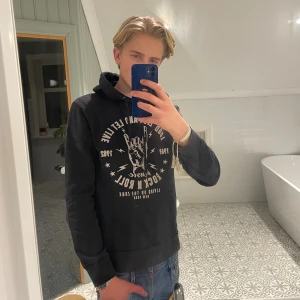 Svart hoodie med rockmotiv - Säljer en riktigt snygg hoodie med rock’n’roll tryck på framsidan🙌🏻 Skick 8/10 (liten tvättfläck, enkel att få bort) Modellen på bilden är 183cm lång Hör av er vid frågor!!💫 Kom med bud!!