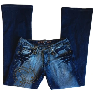 Vintage lowwaist bootcut jeans, y2k/ cyber/ alt/ 2000tal/ 00s/ 2008/ 2009 - Coola lågmidjade utsvängda jeans med ”nitar” på! Midjemått 76,5cm, Grenhöjd 20cm, Innerbenslängd 76cm, Benöppning rakt över 25,5cm 