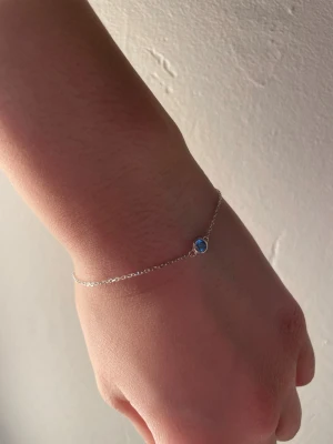 Silvrigt armband med blå diamant  - Säljer ett super fint blått armband från glitter. Använt fåtal gånger men inget som syns. Justerbar. Kontakta om du har frågor eller om du är intresserad!