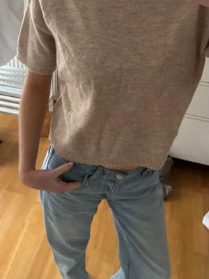 Beige stickad kortärmad tröja - Supermjuk beige stickad tröja med korta ärmar och rund hals. 