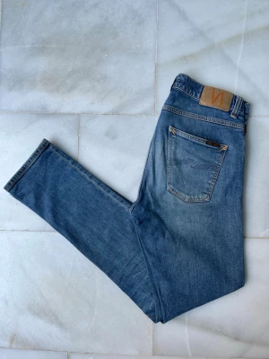 Blå jeans från Nudie Jeans - Väldigt snygga jeans från Nudie Jeans. Modellen är Lean Dean. Om du vill ha bilder hur dom sitter på så hör av dig! 😁                                               ———————————————————————————                                                      📐| Storlek: 29-32                                                  👖| Märke: Nudie Jeans                                         🔎 | Skick: Bra skick!                                               💵 | Ny Pris: 1599kr                                       