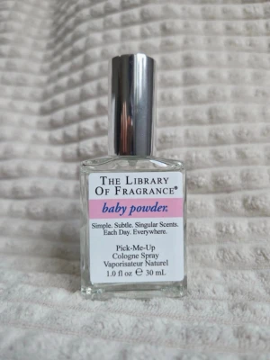 The Library of Fragrance Baby Powder - En parfym från The Library of Fragrance med doften Baby Powder. Flaskan är rektangulär i genomskinligt glas med en silverfärgad spraykork. Innehåller 30 ml och har en enkel, stilren etikett med rosa och svart text. FULL SIZE