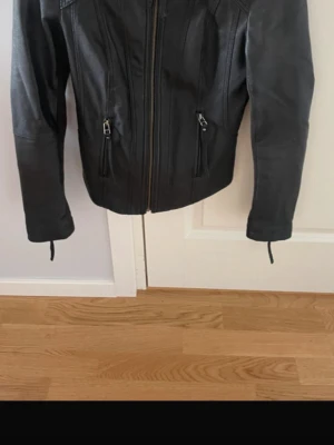 Figursydd Svart skinnjacka🥰 - Snygg svart skinnjacka som har en figursydd passform. Jackan har en hög krage. Perfekt för flera tillfällen😭