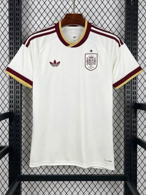Vit Spanien fotbollströja Adidas - Snygg vit fotbollströja från Adidas med Spanien-emblem på bröstet och röda samt gula detaljer på ärmar och krage. Tröjan har klassiska Adidas-ränder på axlarna och broderad logotyp. Materialet är lätt och andas, perfekt för sport och träning.