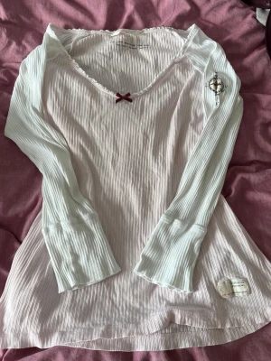 Ljusrosa topp från Odd Molly - Supersöt ljusrosa långärmad topp från Odd Molly med ribbad struktur och liten rosett vid urringningen. Storlek M