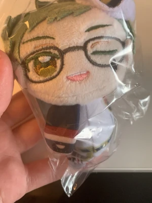 Twisted Wonderland plush nyckelring Trey Clover - Säljer en Twisted Wonderland plush nyckelring från Disney, fortfarande i originalförpackning. Nyckelringen är grön och har en kedja för att fästa på väskan eller nycklar.