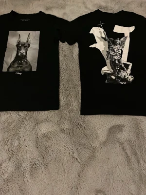 Svart t-shirt med bild på - Säljer 2 st svarta T-shirtar med tryck på. En med en dobberman och en med en ängel. Båda är jättesköna och sitter perfekt i storleken. 150kr/st eller 200kr för båda.