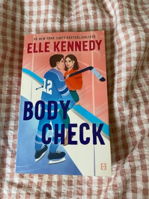 Body Check av Elle Kennedy - Body Check är en skönlitterär bok av Elle Kennedy, känd för sina romantiska berättelser. Boken är pocket och är perfekt för dig som gillar sportromantik. Den är på svenska.