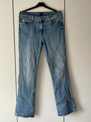 Blå bootcut jeans från Lee - Bootcut jeans från Lee i ljusblå denim. Jeansen har normal midja och dragkedja med knapp💕💕