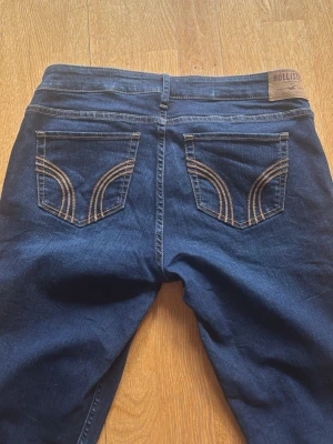 Mörkblå skinny jeans med kontrastsömmar - Snygga mörkblå skinny jeans med klassiska femficksdetaljer och kontrastsömmar på bakfickorna. Jeansen har en låg till medelhög midja och är tillverkade i stretchigt denim som ger en bekväm passform. Perfekt för dig som gillar en slim och modern look.