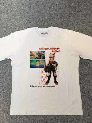 Vit anime t-shirt med Bakugo-motiv - Cool vit t-shirt från UT Uniqlo med tryck av Katsuki Bakugo från My Hero Academia. 59cm på brädden och ca 73 på längden. Hör av dig frågor eller behov av fler bilder!🤗
