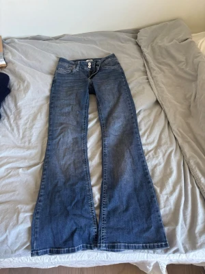 Blå bootcut jeans från Nelly - Snygga blå bootcut jeans från Nelly med brodering på bakfickorna. Passar perfekt till vardags men även när man vill klä upp sig. Säljer pga att de blivit för små för mig. Originalpris 699. Hör av dig för frågor!💗