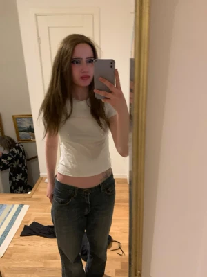 Vit croppad t-shirt  - Säljer en vit croppad t-shirt T-shirten har korta ärmar och en tight passform. Perfekt för dig som gillar en clean och enkel stil.