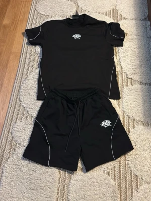 Syna world T-shirt - Säljer en helt ny syna world T-shirt, perfekt för sommaren. Säljer den för att den var för stor på mig. Jag är 180 cm lång och väger runt 67-68kg. SÄLJER BARA T-SHIRTEN OCH INTE SHORTSEN.