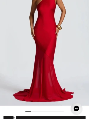 Röd oneshoulder långklänning - Säljer en elegant röd långklänning med oneshoulder-design och öppen rygg. Klänningen har en figurnära passform, släp och knytband i ryggen. Perfekt för dig som vill sticka ut på bal eller fest. Materialet känns mjukt och följsamt.