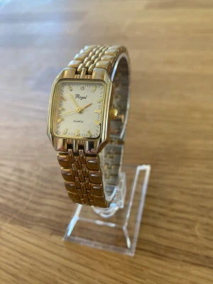 Royal Gold Quartz Damklocka  - Elegant Royal Quartz damklocka med en rektangulär urtavla i guldton. Klockan har en matchande länk i guldton och drivs av ett kvartsurverk. Urtavlan är ljus med diskreta markeringar och visare i guldton. Behöver bara nytt batteri. Skick enligt bilder.  Nypris: 500 SEK Mitt pris: 189 SEK  Skickas alltid snabbt och spårbart. Skriv vid frågor och se gärna mina andra annonser!   GRATIS: För återkommande kunder erbjuder jag personlig experthjälp för dig att göra nya fynd (nytt & begagnat). Fråga för 