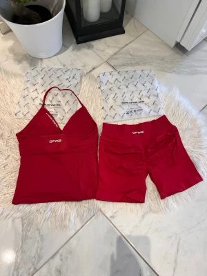 Winter berry DFYNE - Snyggt rött bodyset från DFYNE med halterneck-linne och matchande shorts. Setet har logotypen tryckt på både linne och shorts samt texten 'Let nobody DFYNE you' på insidan av linningen. Materialet är stretchigt och mjukt, perfekt för att känna sig bekväm och stylish. Impact: 4.5 
