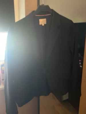 Svart kavaj från STOCKH LM - aldrig använd, Säljer en klassisk svart kavaj från STOCKH LM i storlek 40. Kavajen har en skräddad passform med krage och långa ärmar. Perfekt att matcha med jeans eller dressade byxor för en snygg look.