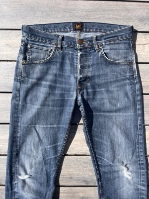 Lee Jeans Archive blå tvätt - Lee jeans med en galet fet tvätt och snygga slitningar! Fint skick inga defekter! Storlek 31/32 men passar även w30. Kontakta mig för fler frågor och funderingar!