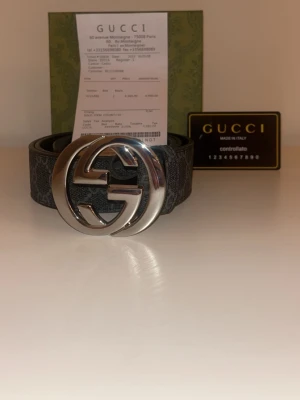 Svart Gucci skärp med stor logga - Snyggt svart skärp från Gucci med GG-monogram och stor silverfärgad logga som spänne. Skärpet har ett klassiskt mönster och är gjort i skinn. Perfekt för att lyfta vilken outfit som helst.