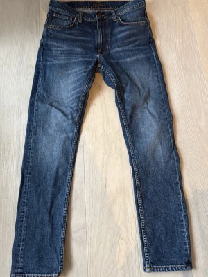 Mörkblå jeans från Nudie Jeans - Mörkblå jeans från Nudie Jeans i storlek 30 W 30 L sitter slim på benen, såklart bra skick använd få tal gånger, hör av er vid minsta fundering!😊