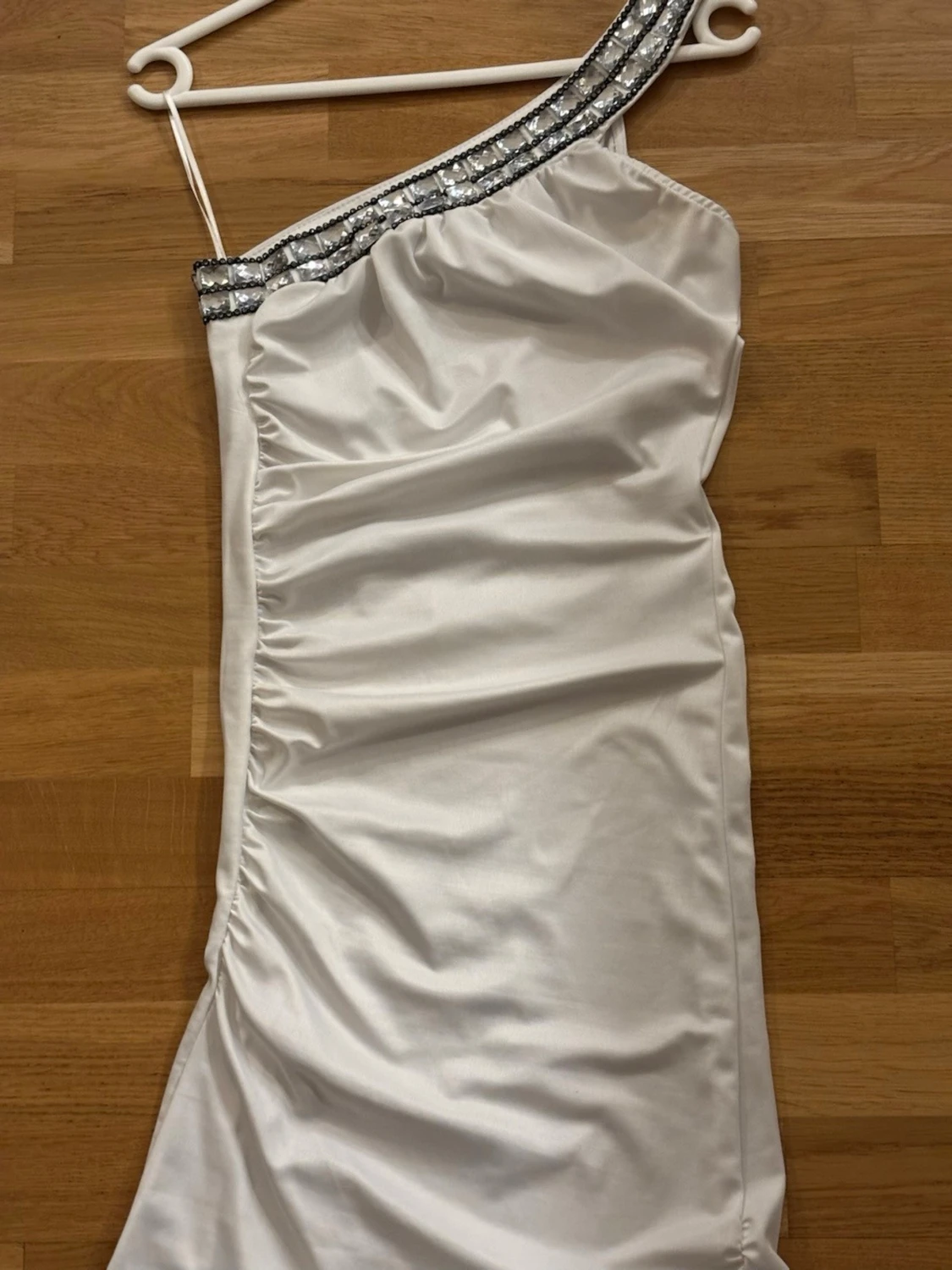 Vit oneshoulder klänning med paljetter.