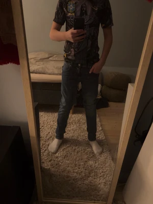 Mörkblå slim fit jeans herr - Säljer ett par mörkblå slim fit jeans med klassisk femficksdesign och normal midja. Jeansen har smal passform hela vägen ner och är tillverkade i ett stretchigt denimtyg för extra komfort. Perfekta för en avslappnad och trendig look.