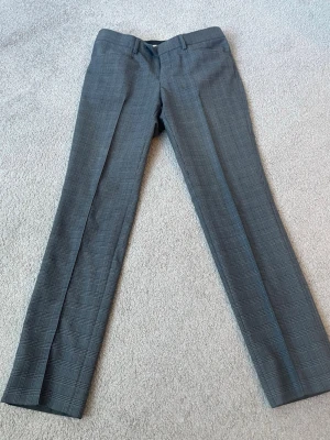 Rutiga kostymbyxor Tiger of Sweden - Grå kostymbyxor från Tiger of Sweden med diskret rutmönster i mycket bra skick och storlek 48. Pris kan diskuteras 