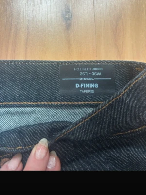Mörkblå tapered jeans från Diesel - Snygga mörkblå jeans från Diesel, modell D-FINING Tapered. Midjemått: 44 Inbenslängd: 78 längd: 104