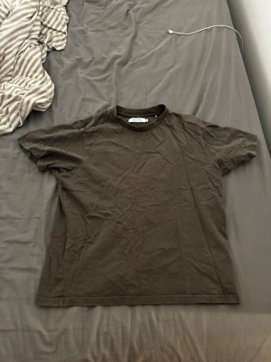 Mörkgrön t-shirt från Ljung - En basic mörkbrun t-shirt från Ljung Marcus Larsson. Klassisk rund halsringning och korta ärmar. Störlek M