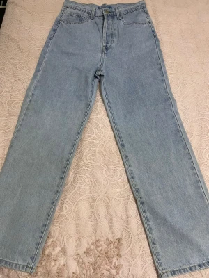 Ljusblå raka jeans från Artlove - Säljer ett par ljusblå jeans från Artlove i rak modell med hög midja. Klassisk femficksdesign och gylf med dragkedja och knapp. Perfekta till en avslappnad och trendig look. Materialet är klassisk denim i bomull.