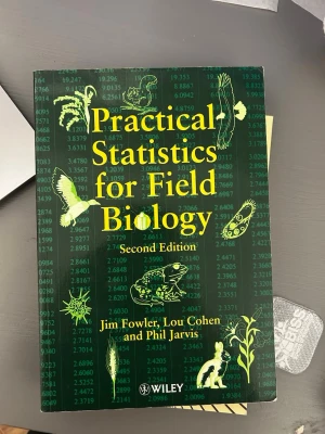 Practical Statistics for Field Biology - Praktisk kursbok i statistik för fältbiologi, andra upplagan, skriven av Jim Fowler, Lou Cohen och Phil Jarvis. Omslaget är grönt med gula och vita illustrationer av djur och växter samt siffror i bakgrunden. Perfekt för biologistudenter.