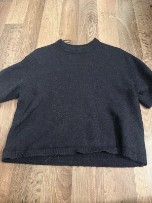 Blå stickad tröja med kort ärm - En enkel blå stickad tröja med korta ärmar och rund hals. 