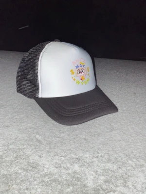 Svartvit truckerkeps Anita Max Wynn - Fet truckerkeps med tryck på framsidan som säger ”Anita Max Wynn” riktig fet nu till våren och sommaren som kommer. Vid frågor så är de bara å skriva.