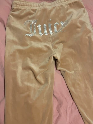 Beiga velour sett från Juicy Couture - Mysiga beige sett i velour från Juicy Couture med glittrande 'Juicy'-text baktill.