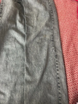 Grå  raka jeans - Säljer ett par grå tvättade jeans med rak passform och klassiska bakfickor. Jeansen har en vintagekänsla och är tillverkade i denim. Perfekta för dig som gillar en avslappnad och trendig stil.