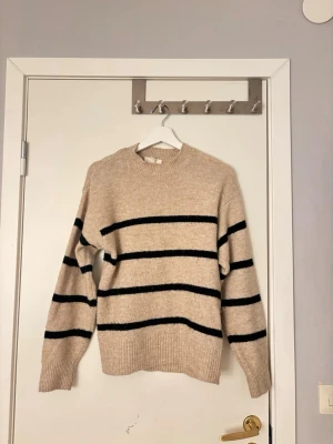 Beige stickad tröja med svarta ränder - Söt stickad tröja från HM. Använd ett x antal gånger men fortfarande i otroligt bra skick.🤎