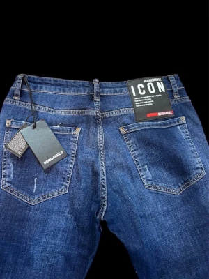 Mörkblå dsquared jeans från Ibrahimovic - Snygga mörkblå dsquared jeans från Ibrahimovic med raka ben och diskreta slitningar framtill. Klassisk femficksmodell med detaljerade sömmar och logga på linningen. Perfekta för en avslappnad och trendig look. Och pris kan diskuteras.