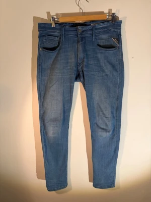 Replay Anbass - 1 Par ljusblåa Replay Anbass med riktigt snygg tvätt. Storlek 31/32. Jeansen är i superbra skick, nypris: 1499kr. Tveka inte på att höra av er om ni har några funderingar!