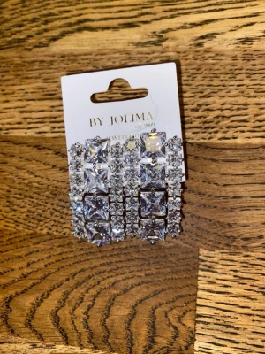By Jolima örhängen  - Festörhängen i äkta silver med cubic zirkoniastenar .mått längd 2 cm bredd 1 cm. Aldrig använda