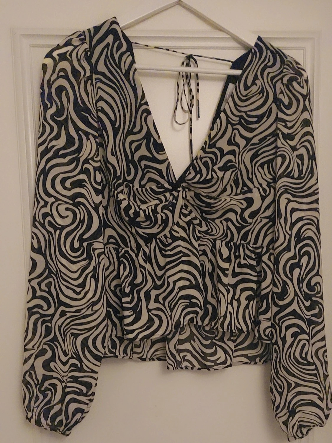 Svartvit mönstrad blus med v-ringning