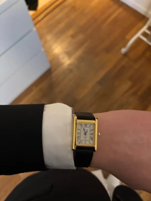 Cartier Tank klocka liknande - En stilren Cartier liknade klocka med ett fyrkantigt ur och ett stilrent svart läder band. Den är helt ny och passar till alla outfits.