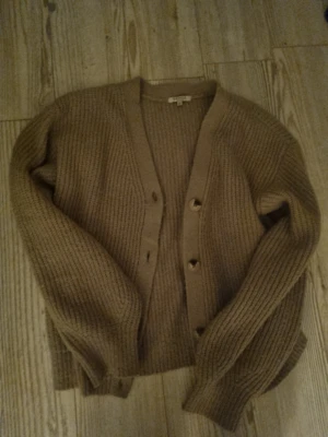 Beige kofta från SAMSA Young - Mysig beige kofta från SAMSA Young i stickat material. Koftan har v-ringning, knäppning framtill med fyra knappar. Perfekt till våren!. Kan sänka till till 50 vid snabbt köp!