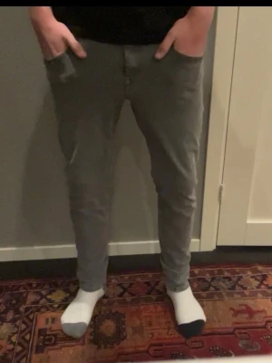 Gråa slim fit jeans från replay - Snygga gråa slim fit jeans med klassisk femficksdesign och normalhög midja. Jeansen har smal passform hela vägen ner och stängs med dragkedja och knapp. Perfekta för dig som gillar en modern och enkel stil.